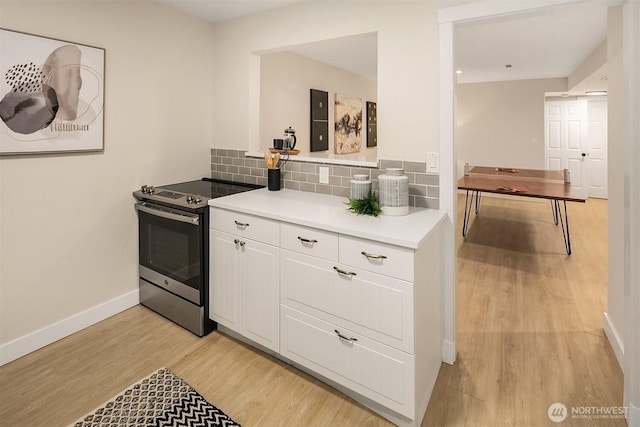 11820 NE 145th St, Kirkland, WA 98034 - kitchen featuring light wood-style floors, light countertops, electric range, white cabinets, and backsplash