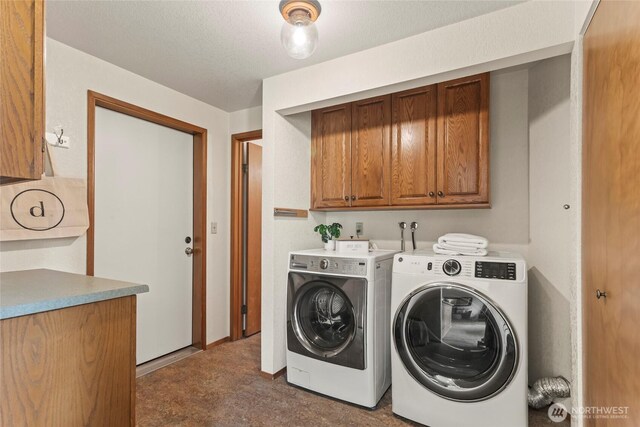 washroom featuring washing machine and dryer and cabinet space