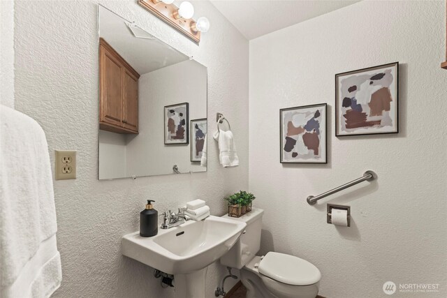 half bath with toilet and a sink
