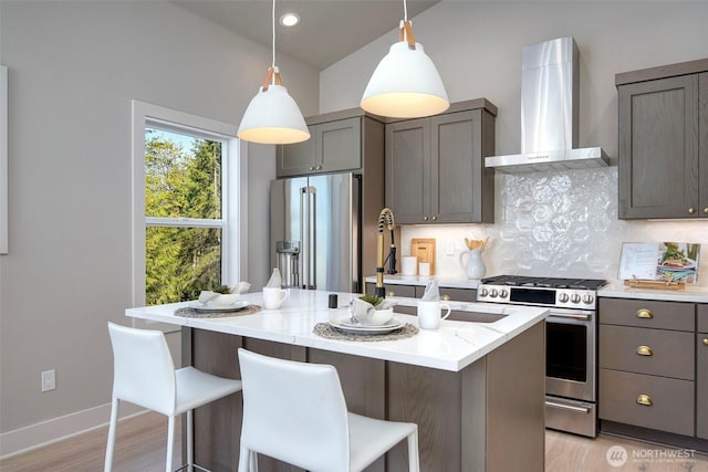 428 20th Ave, Kirkland, WA 98033 - kitchen with wall chimney exhaust hood, stainless steel appliances, lofted ceiling, a kitchen island with sink, and a breakfast bar