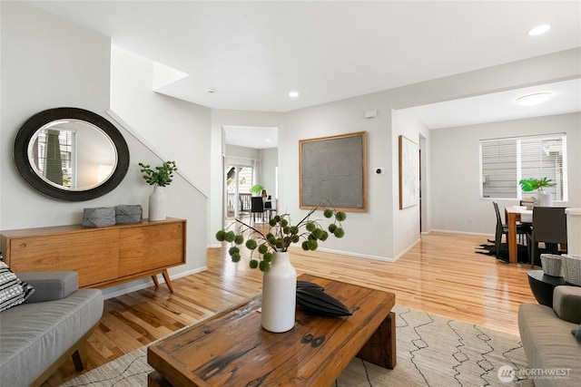 living area with light wood-type flooring, recessed lighting, and baseboards