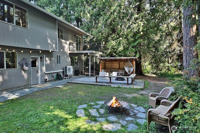 view of yard featuring an outdoor fire pit, a balcony, and a patio