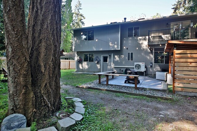 rear view of property featuring ac unit, a patio area, a fire pit, and fence