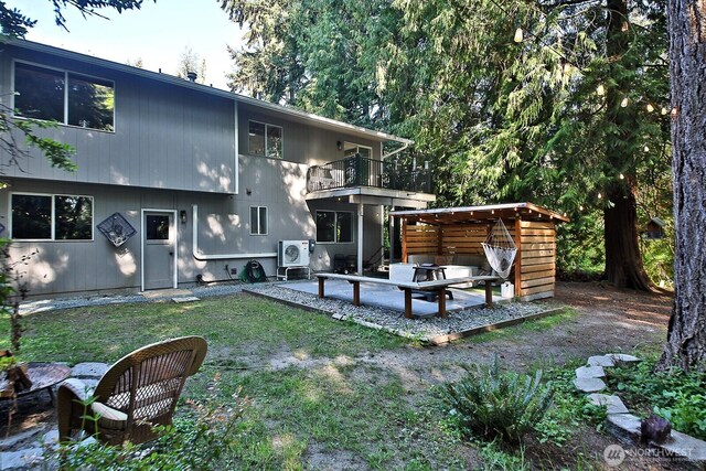 rear view of property featuring a patio area, ac unit, a lawn, and a balcony