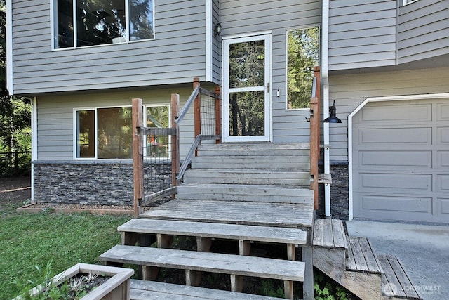 doorway to property with stone siding and a garage