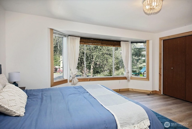 bedroom featuring visible vents, wood finished floors, and baseboards