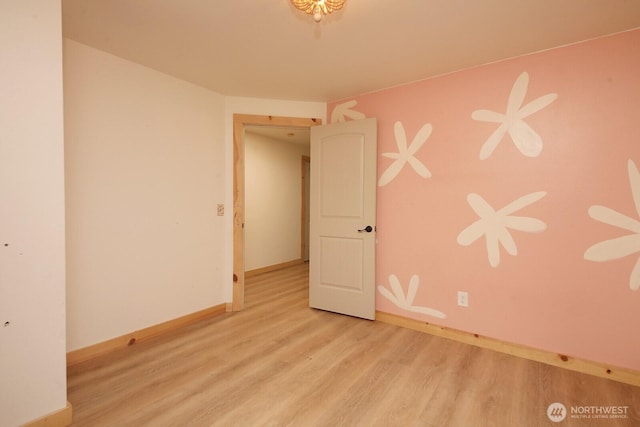 unfurnished room with baseboards and wood finished floors