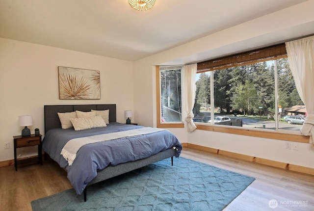 bedroom with baseboards and wood finished floors