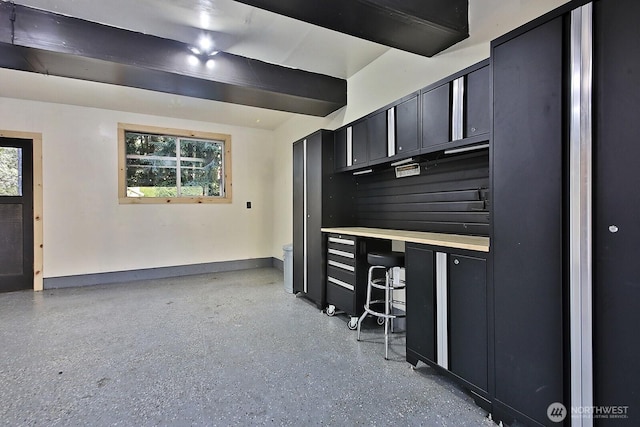 kitchen with baseboards, a wealth of natural light, dark cabinets, and speckled floor