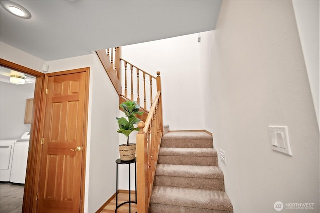 stairway featuring baseboards and washer and clothes dryer
