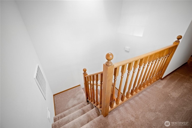 stairway with baseboards, visible vents, and carpet