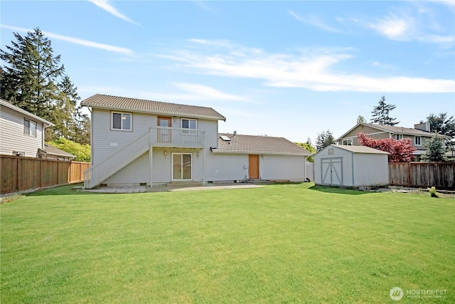 back of house featuring an outdoor structure, a yard, a shed, and a fenced backyard
