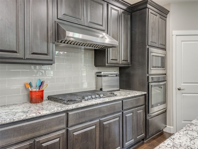 4206 NE 132nd St, Vancouver, WA 98686 - kitchen with decorative backsplash, under cabinet range hood, dark brown cabinetry, and appliances with stainless steel finishes