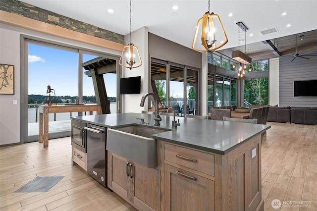 kitchen with visible vents, a sink, open floor plan, a wealth of natural light, and dark countertops
