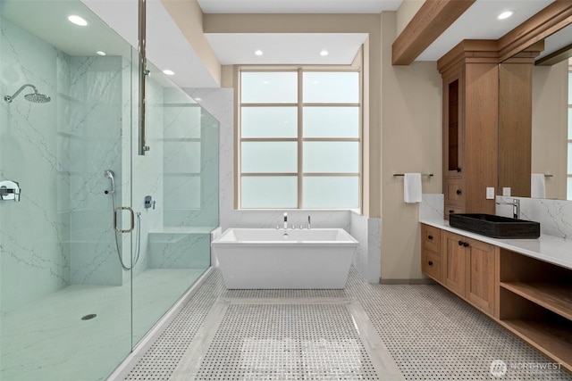 full bathroom with a freestanding bath, recessed lighting, vanity, and a marble finish shower