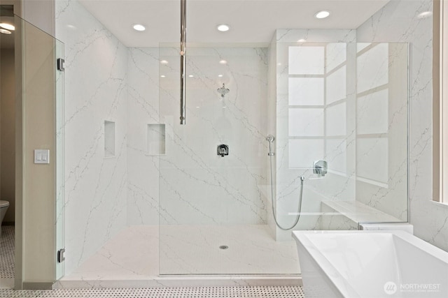 bathroom featuring a marble finish shower, recessed lighting, and a freestanding tub