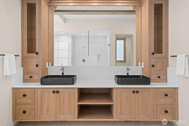 full bathroom featuring walk in shower, double vanity, and a sink
