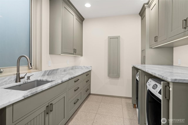 washroom featuring a sink, baseboards, washer / dryer, and recessed lighting