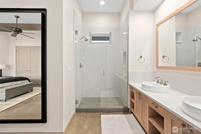 full bath with double vanity, a sink, a stall shower, and ceiling fan