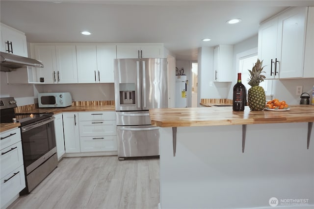 12501 50th Pl S, Seattle, WA 98178 - kitchen with under cabinet range hood, white cabinets, appliances with stainless steel finishes, and wooden counters