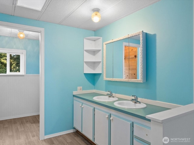 5255 Apollo Rd, Langley, WA 98260 - bathroom featuring double vanity, a sink, wood finished floors, and baseboards