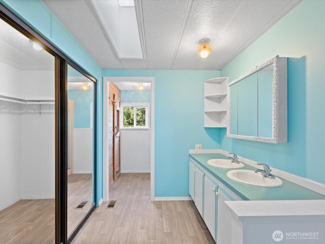 5255 Apollo Rd, Langley, WA 98260 - full bath featuring a textured ceiling, wood finished floors, a walk in closet, and a sink