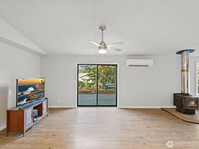5255 Apollo Rd, Langley, WA 98260 - unfurnished living room featuring a wood stove, ceiling fan, a wall unit AC, and light wood-type flooring