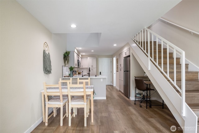 dining area with recessed lighting, stairway, baseboards, and wood finished floors