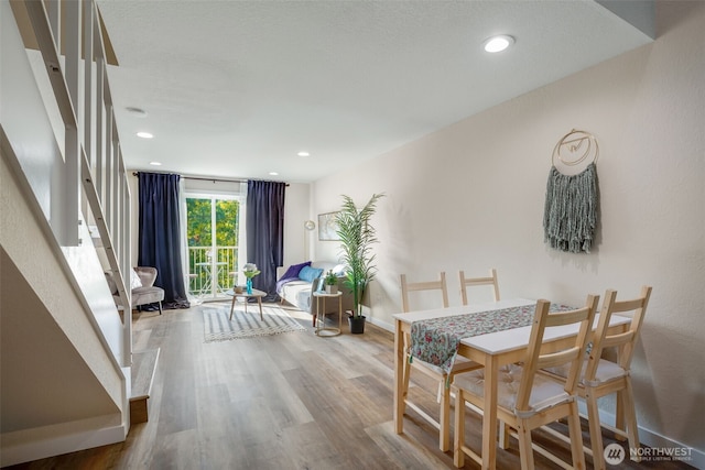 dining space with wood finished floors, recessed lighting, baseboards, and stairs