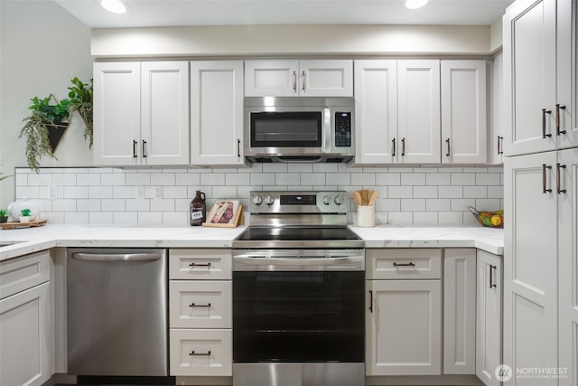 kitchen with tasteful backsplash, light stone counters, and appliances with stainless steel finishes