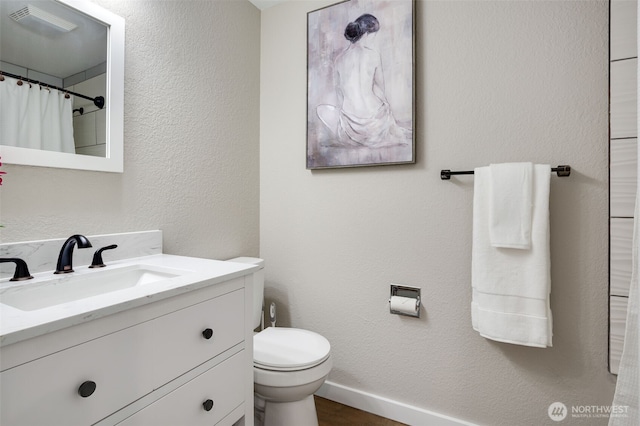 bathroom featuring baseboards, curtained shower, toilet, vanity, and wood finished floors