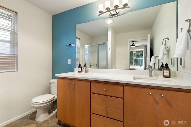 bathroom with toilet, a sink, double vanity, and a stall shower