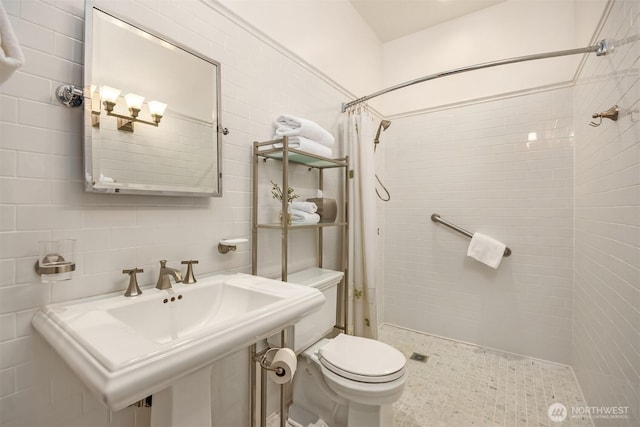 bathroom with a shower stall, toilet, and tile walls
