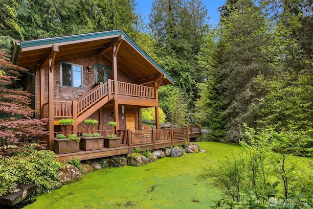 rear view of house with a yard and a wooden deck
