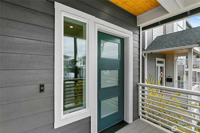 entrance to property featuring a shingled roof