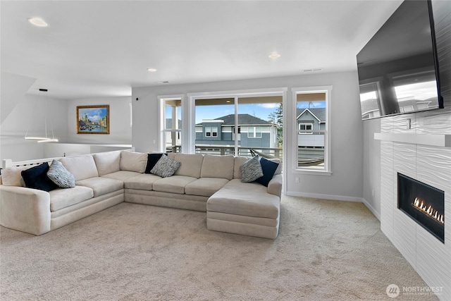 living room with baseboards, carpet, recessed lighting, and a tile fireplace