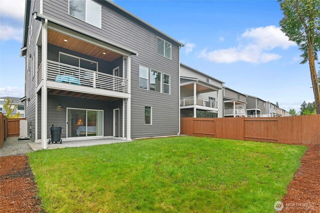 rear view of house featuring a lawn, a patio, and a fenced backyard