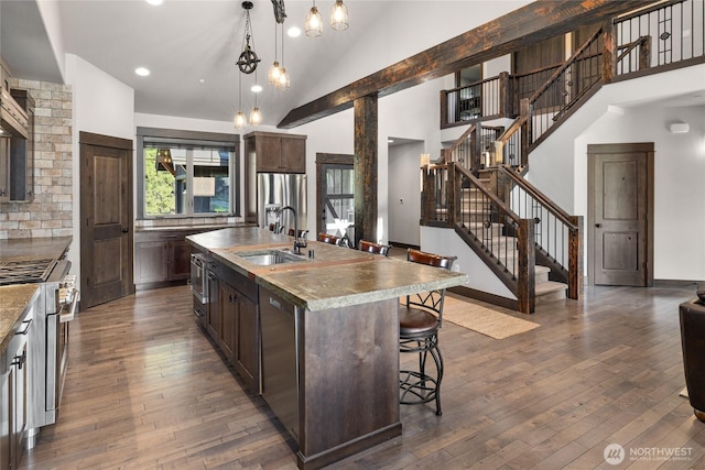 70 Monabel Ct, Cle Elum, WA 98922 - kitchen with a sink, appliances with stainless steel finishes, a breakfast bar, and dark brown cabinetry
