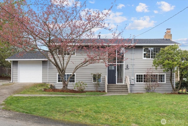 bi-level home featuring a chimney, aphalt driveway, a front yard, entry steps, and a garage