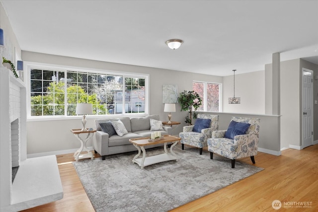 living room with light wood-style flooring, baseboards, and a wealth of natural light