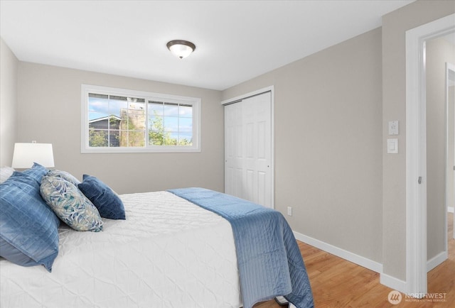 bedroom featuring a closet, baseboards, and wood finished floors