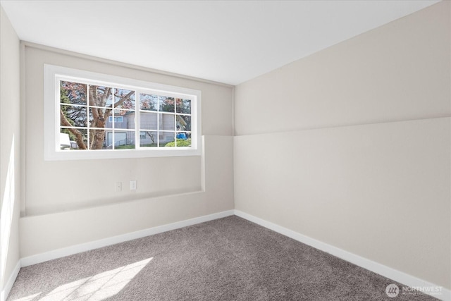 carpeted spare room featuring baseboards