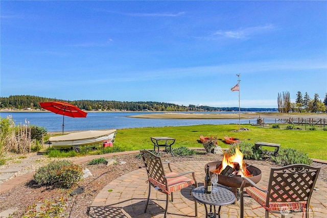view of patio / terrace with an outdoor fire pit and a water view