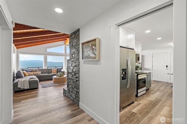 hallway featuring recessed lighting, lofted ceiling with beams, light wood-style flooring, and baseboards