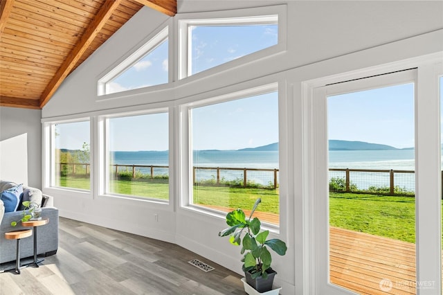 sunroom / solarium featuring visible vents, a water view, and beam ceiling