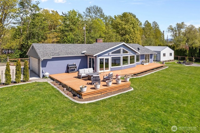 back of property with a chimney, a wooden deck, a garage, a yard, and outdoor lounge area
