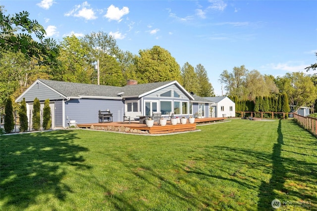 back of house with a wooden deck, a yard, a chimney, and fence