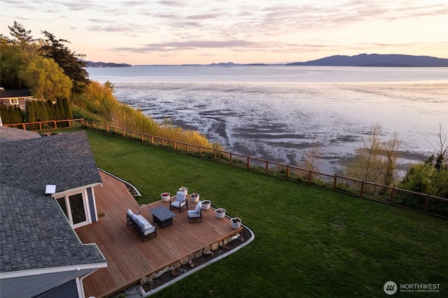 view of yard featuring fence and a deck with water view