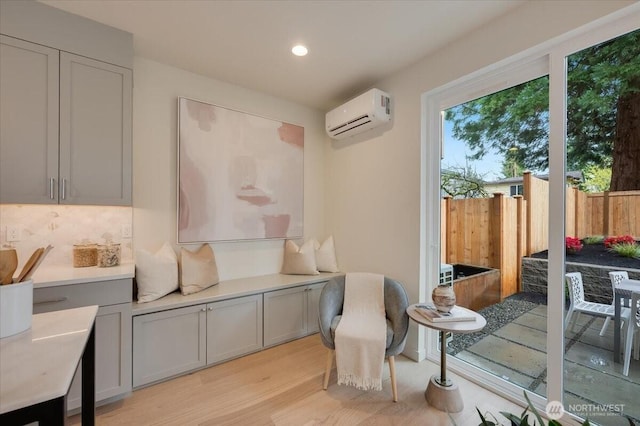 sitting room featuring recessed lighting, a wall mounted air conditioner, and light wood finished floors