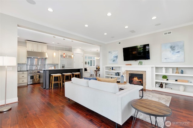 3048 39th Ave W, Seattle, WA 98199 - living area featuring crown molding, visible vents, a glass covered fireplace, dark wood-style floors, and recessed lighting